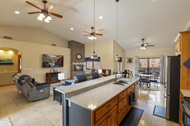 kitchen with appliances with stainless steel finishes, open floor plan, visible vents, and a sink