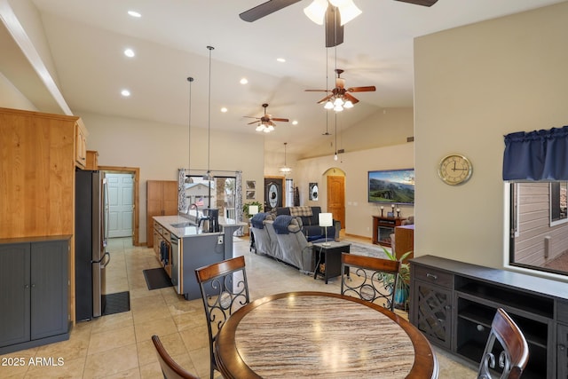 dining space featuring light tile patterned floors, high vaulted ceiling, arched walkways, and recessed lighting