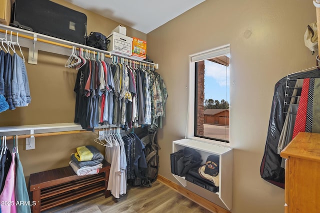 walk in closet with wood finished floors