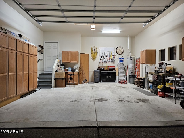 garage with a garage door opener, gas water heater, and a workshop area