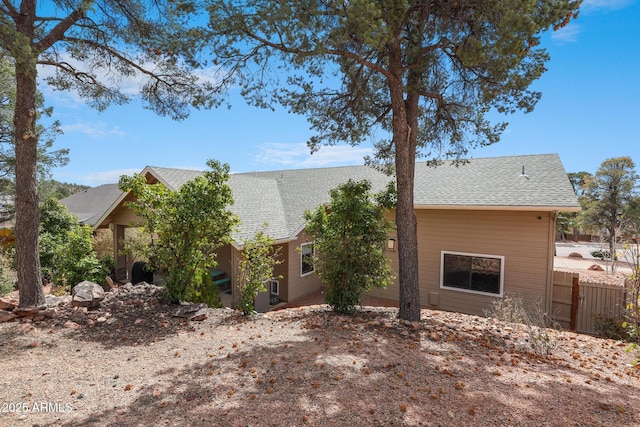 view of front of property featuring fence and roof with shingles