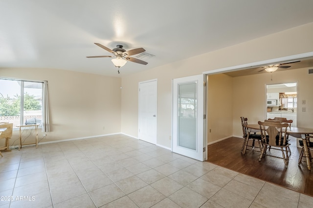 tiled empty room featuring ceiling fan