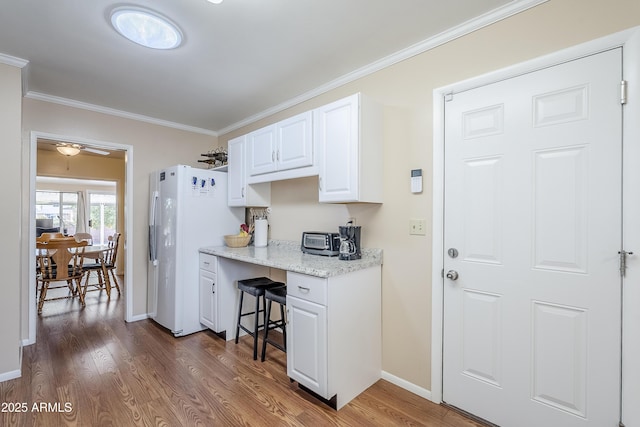 kitchen with ornamental molding, dark hardwood / wood-style floors, white cabinets, and white fridge