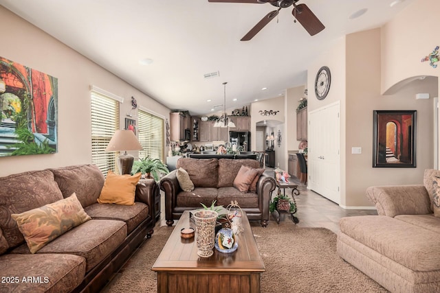 tiled living room featuring ceiling fan and lofted ceiling