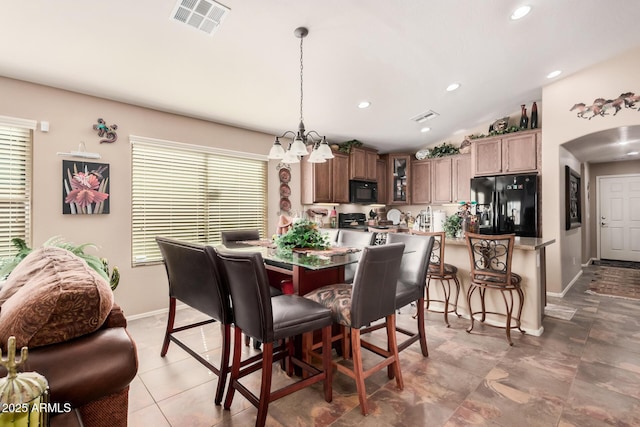 dining area featuring vaulted ceiling and a chandelier