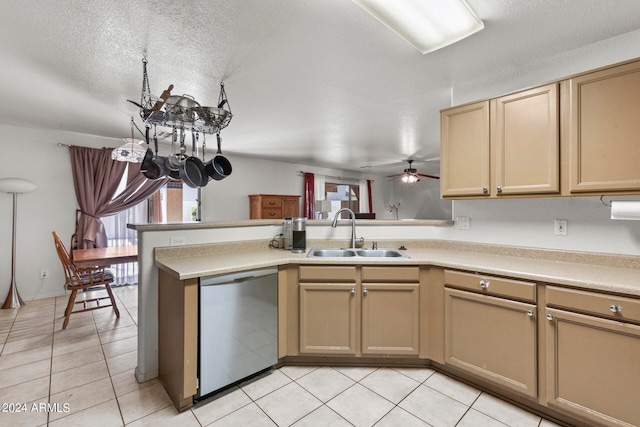 kitchen with sink, stainless steel dishwasher, a textured ceiling, light tile patterned flooring, and kitchen peninsula