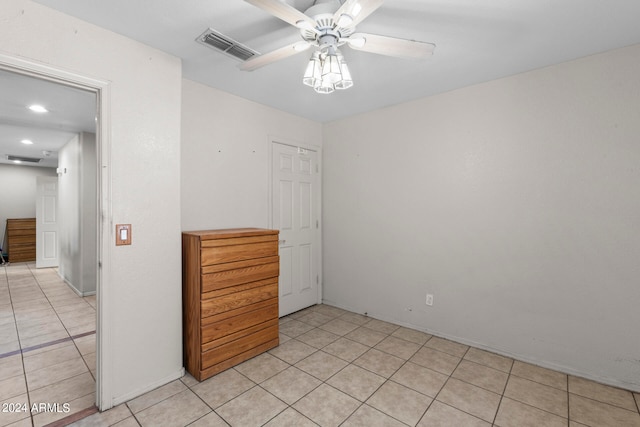 tiled spare room with ceiling fan