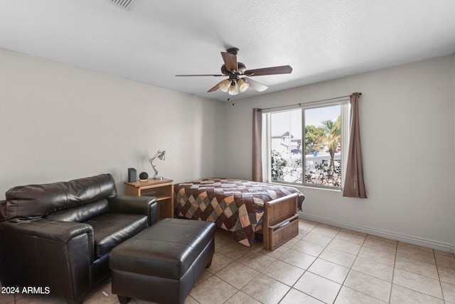 tiled bedroom with ceiling fan and a textured ceiling