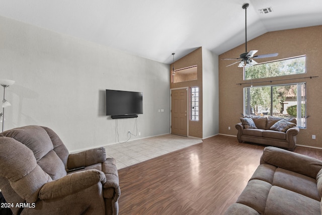 living room with ceiling fan, high vaulted ceiling, and light hardwood / wood-style flooring