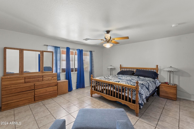 tiled bedroom with ceiling fan and a textured ceiling