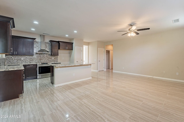 kitchen featuring decorative backsplash, wall chimney exhaust hood, sink, a center island, and stainless steel range with electric cooktop