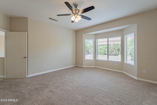 carpeted spare room featuring ceiling fan