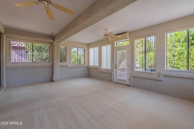 unfurnished sunroom with beam ceiling, a healthy amount of sunlight, and ceiling fan