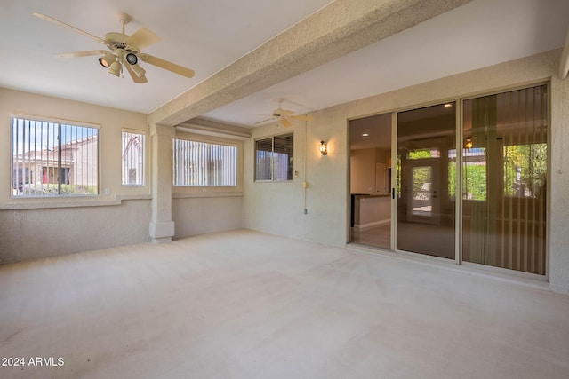 unfurnished sunroom with ceiling fan