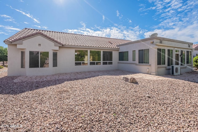 back of house with a sunroom, a patio area, and ac unit