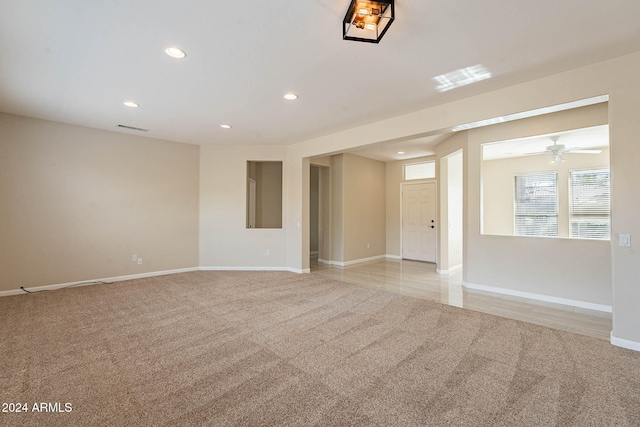 unfurnished room featuring light carpet and ceiling fan