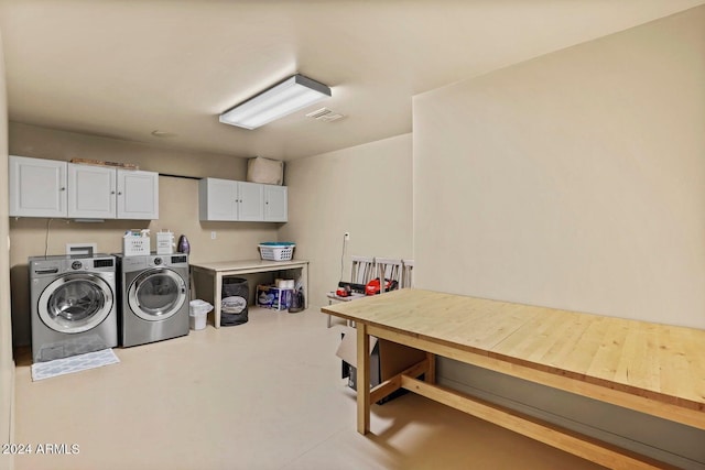 laundry room featuring cabinets and washer and clothes dryer