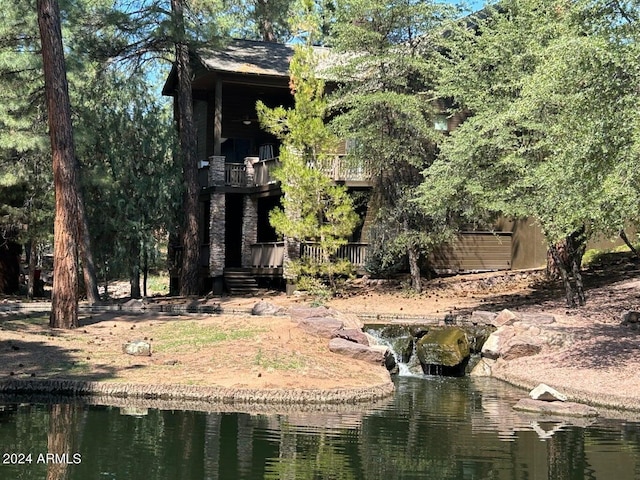 rear view of house featuring a balcony and a water view