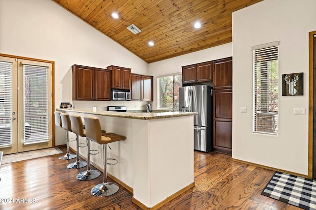 kitchen featuring a kitchen bar, wooden ceiling, dark hardwood / wood-style floors, stainless steel appliances, and light stone countertops