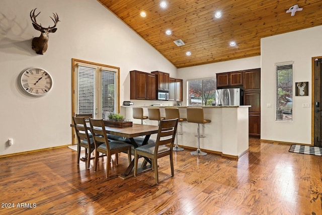 dining space featuring high vaulted ceiling, light hardwood / wood-style flooring, and wooden ceiling