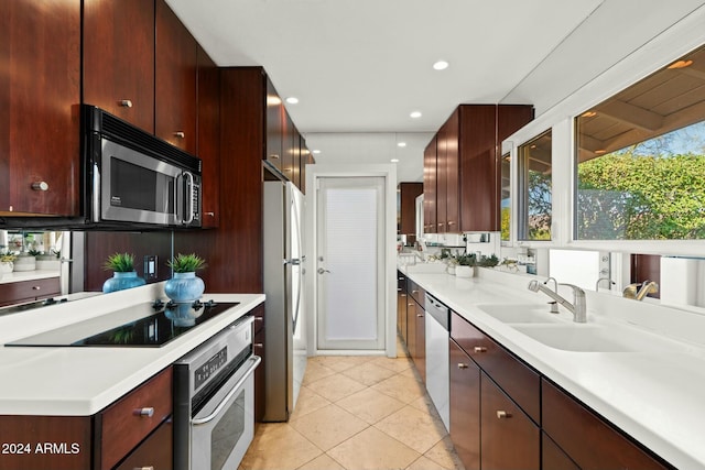 kitchen with light tile patterned floors, stainless steel appliances, and sink