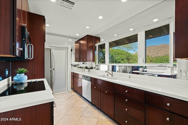 kitchen featuring light tile patterned flooring, appliances with stainless steel finishes, and sink