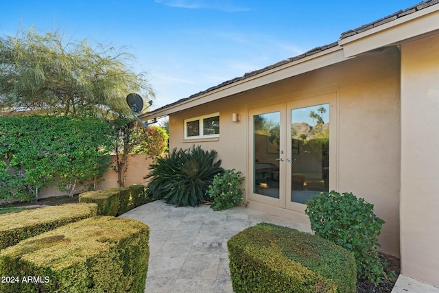 view of exterior entry with french doors and a patio