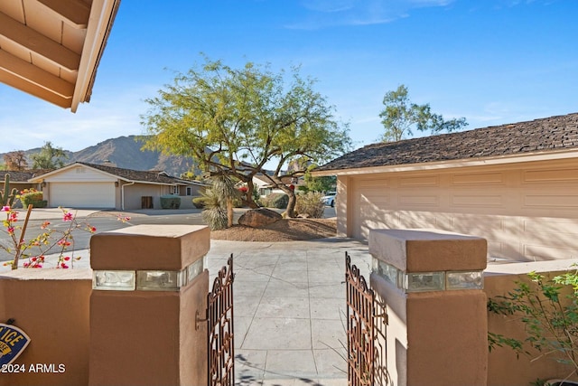 view of patio featuring a mountain view, an outbuilding, and a garage