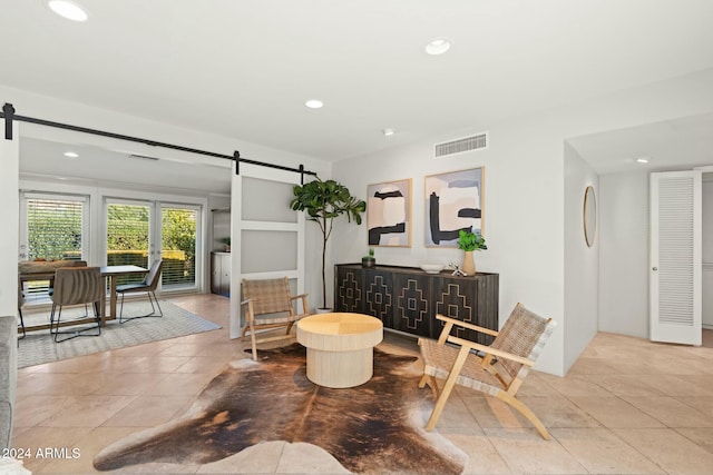 interior space featuring a barn door and light tile patterned floors