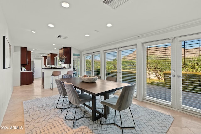 dining space featuring lofted ceiling and light tile patterned floors