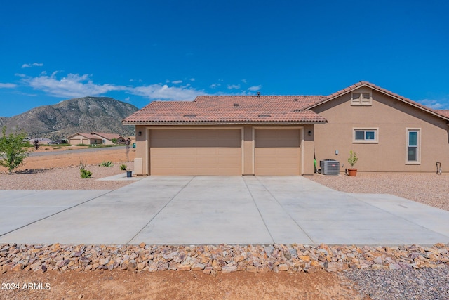 view of front of house with a tile roof, a mountain view, cooling unit, and stucco siding