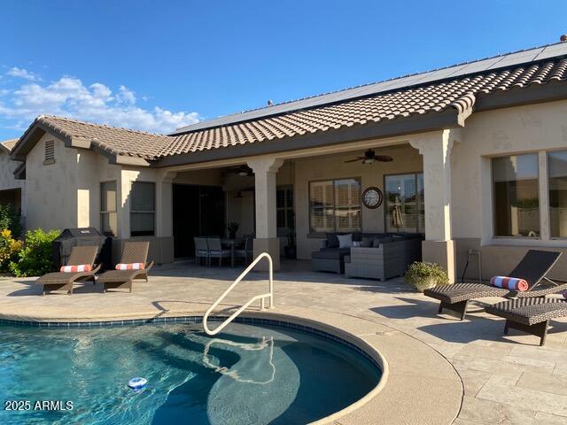 rear view of property with ceiling fan and a patio area