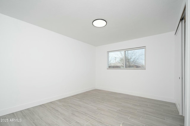 empty room with wood tiled floor and baseboards