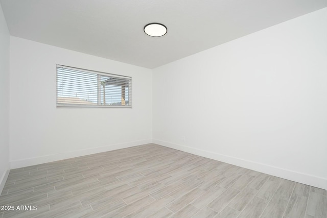 spare room with baseboards and wood tiled floor