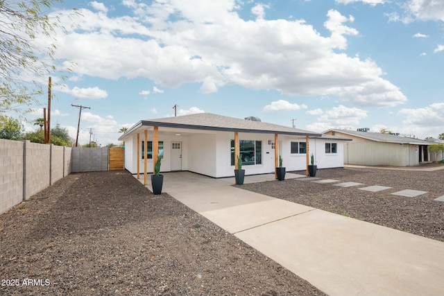 view of front of house with a gate, fence, and stucco siding