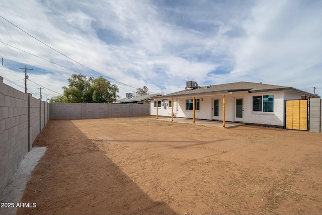 back of property featuring a patio, brick siding, and a fenced backyard