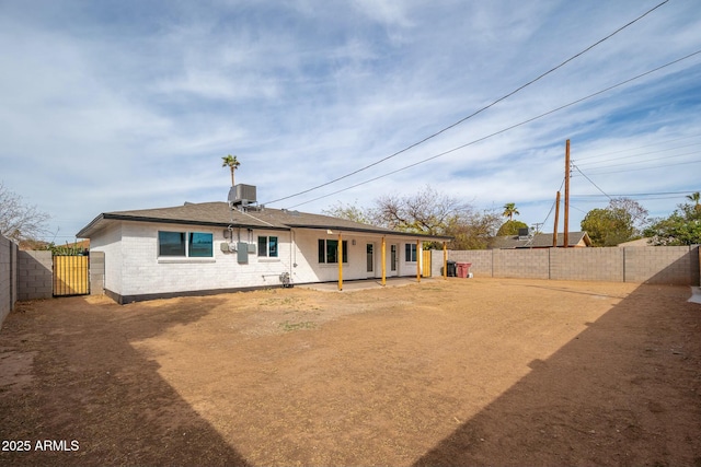 rear view of house featuring a fenced backyard, central AC unit, and brick siding