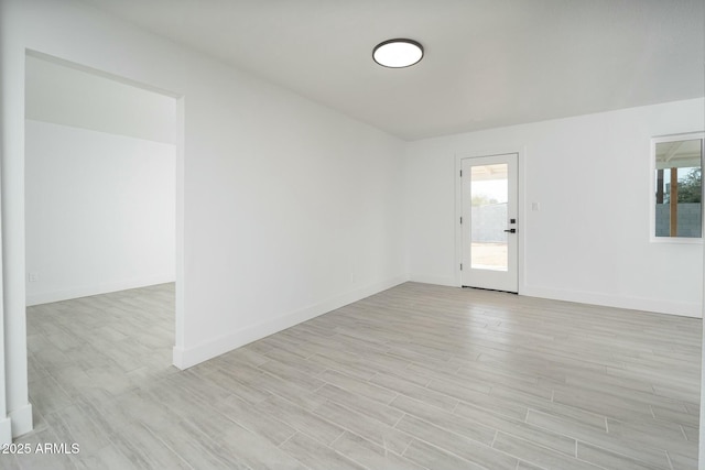 spare room with light wood finished floors and baseboards