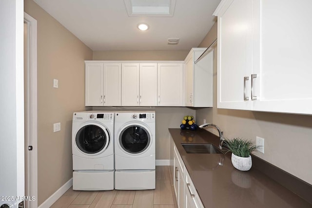 washroom with a sink, washer and dryer, recessed lighting, cabinet space, and baseboards