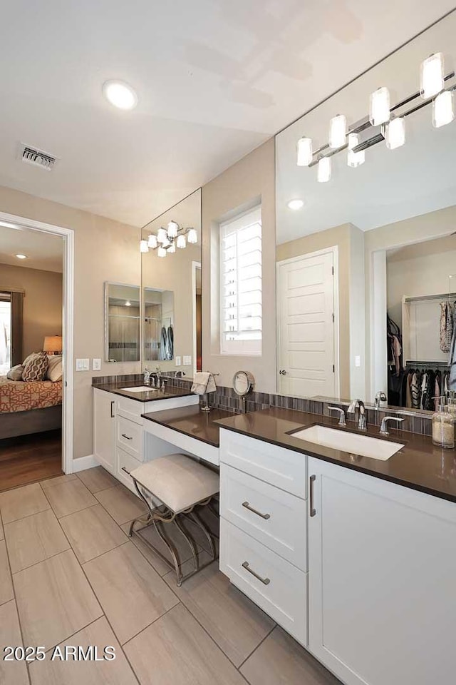 ensuite bathroom featuring visible vents, vanity, and ensuite bathroom