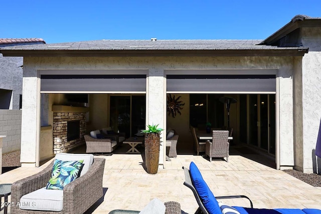 view of patio / terrace featuring outdoor dining space and an outdoor living space with a fireplace