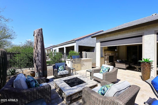 view of patio with an outdoor living space with a fire pit, exterior kitchen, fence, and grilling area