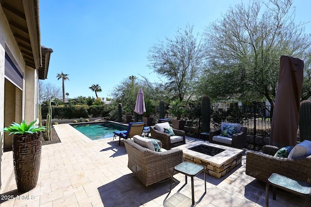 view of patio / terrace with a fenced in pool, an outdoor living space with a fire pit, and a fenced backyard