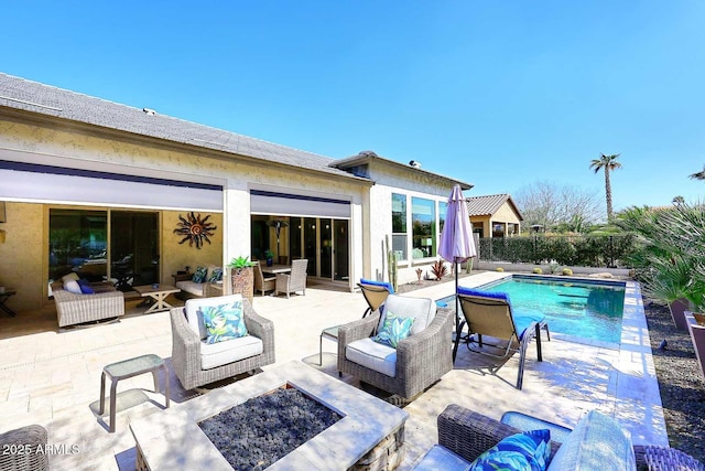 view of pool with a fenced in pool, an outdoor living space with a fire pit, and a patio