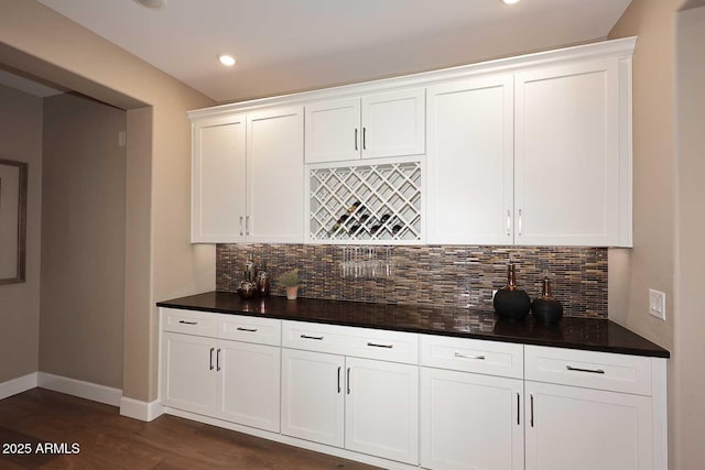 bar with baseboards, dark wood finished floors, wet bar, recessed lighting, and decorative backsplash