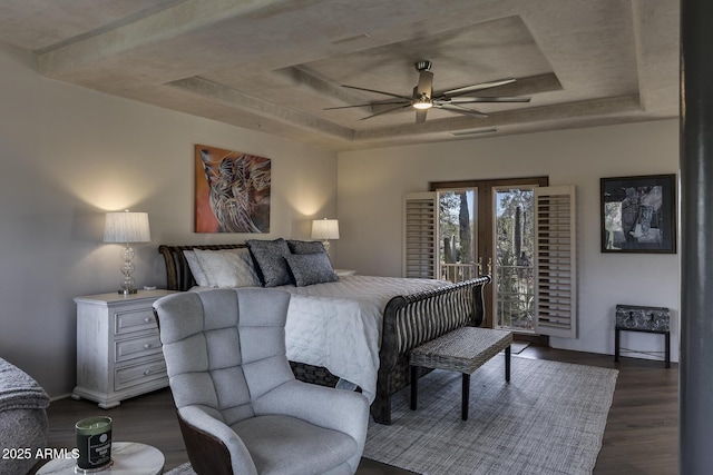 bedroom featuring ceiling fan, dark hardwood / wood-style floors, french doors, access to outside, and a raised ceiling