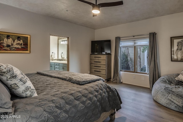 bedroom featuring wood-type flooring, ensuite bathroom, and ceiling fan