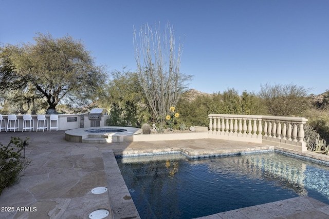 view of swimming pool featuring a patio and an in ground hot tub