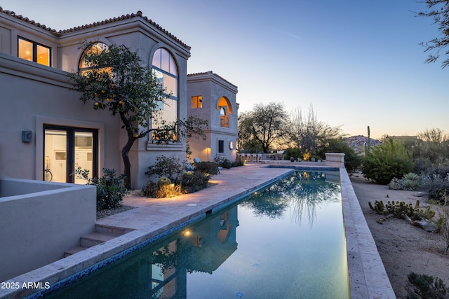 pool at dusk with a patio