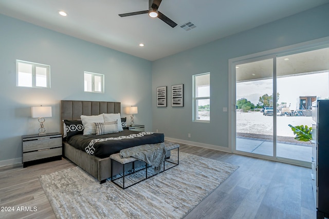 bedroom with access to outside, multiple windows, light hardwood / wood-style floors, and ceiling fan